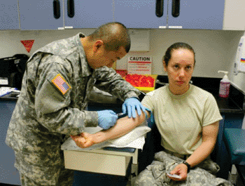 Image: Sgt. Christopher Funke, noncommissioned officer-in-charge of Nuclear Medicine at General Leonard Wood Army Community Hospital, injects Pfc. Sara Reagers, C Company, 84th Chemical Battalion, with a radiopharmaceutical agent (Photo courtesy of John Brooks). 